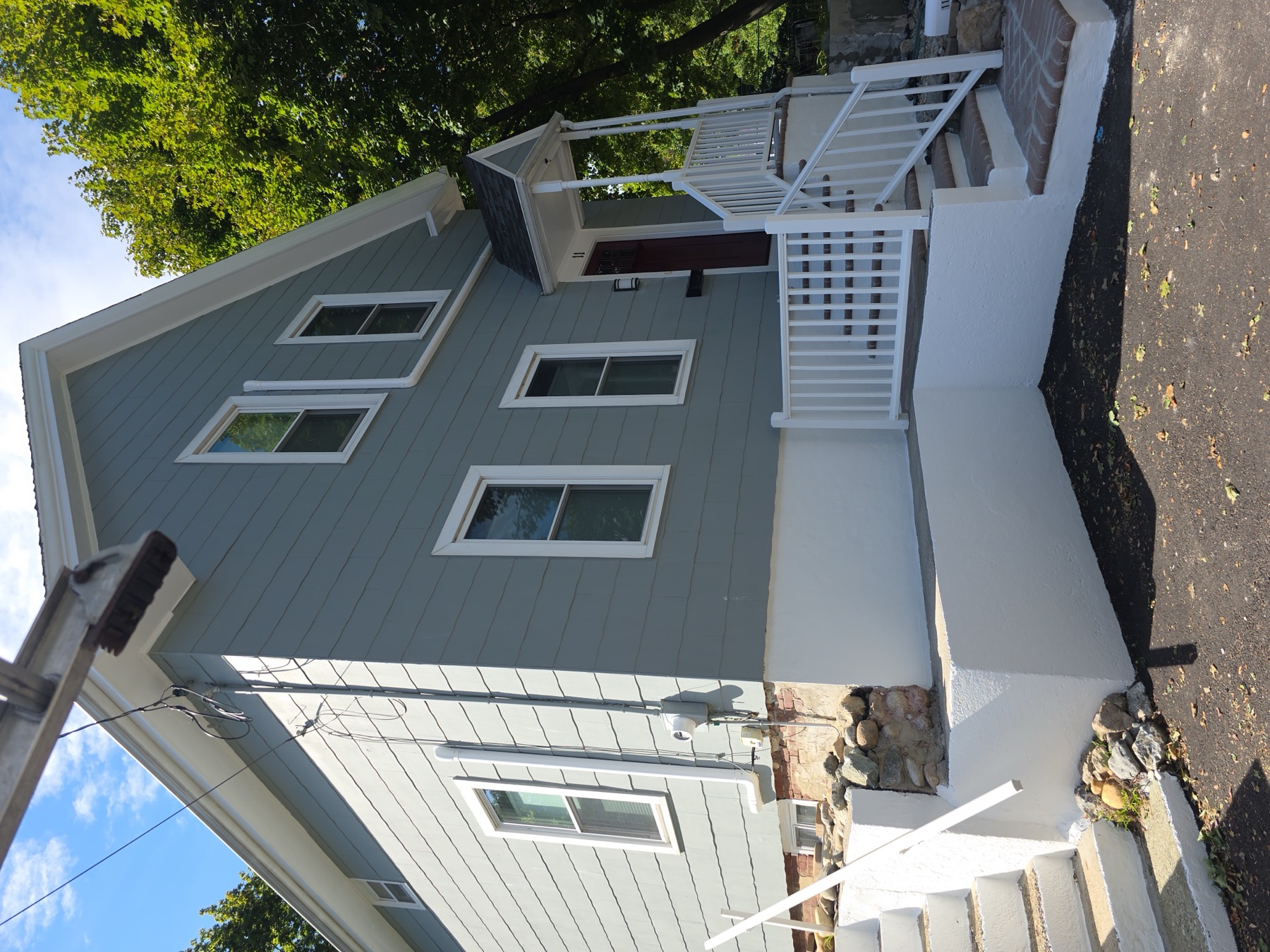 Finished exterior repaint of a blue-gray shingle-style home